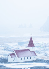 Vertical Shot Of A White Church With A Red Roof In Winter Under A Foggy Sky