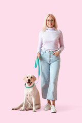 Poster - Mature woman with cute Labrador dog on pink background