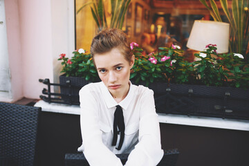 pretty woman with short hair is walking down the street with a book in her hands