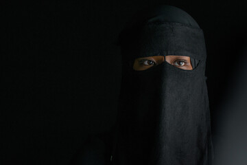 Wall Mural - Closeup, teen girl in dress traditional Muslim style with Niqab veil, on black background