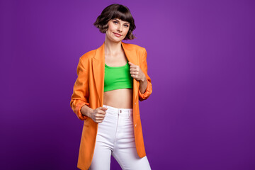 Wall Mural - Photo of charming adorable young woman dressed orange blazer empty space smiling isolated purple color background