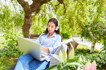 Freelancer in the green garden in summer on the laptop