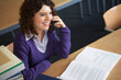 © ER Creative Services - Smiling female student talking on smart phone at desk in library