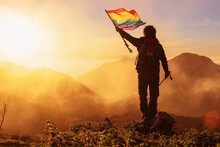 Hiker With Backpack And Trekking Poles Waving An Lgbt Pride Flag Demanding The Inclusion And Respect Of Gay People In Sport.