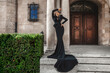 Elegant fashion. Young woman in elegant long dress on palace background. Fashion model in gown dress outdoor. Elegance.