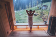 © Soloviova Liudmyla - Relaxing Woman wrapped white towel in Hot Finnish sauna with a huge wide window enjoying the green forest view and pleasant healthy body care temperature treatment. Body healthcare prevention concept