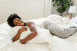 © Louis-Paul Photo - beautiful young African woman in tank top lying in bed