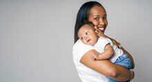 Portrait Of Beautiful African Woman Holding On Hands Her Little Son On Grey Background