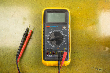 Multimeter with buttons and cables on table