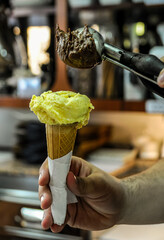 Poster - Vertical shot of a person adding another scoop of ice cream on the ice cream cone