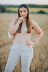 Poster - Vertical shot of a young Caucasian female model posing in a wheat field