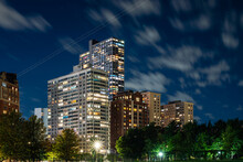 Long Exposure Of Clouds Moving Across A Dark Blue Sky Over Modern Residential Highrise Buildings In The Lakeview Neighborhood Along Lake Shore Drive In Chicago At Night.