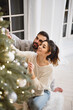 © Olena Bloshchynska - Charming couple in love decorating Christmas tree.