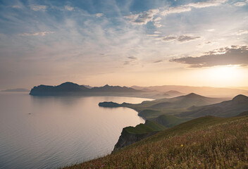 Stunning scenery in the sunset rays of the sea coast and mountains. Black Sea coast, view of Koktebel, massif Karadag