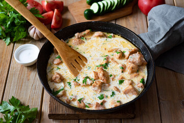 Hearty family dinner: pork goulash in cream sauce in a frying pan. Beef Stroganoff with bechamel sauce in a frying pan. Close-up