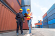 © InfiniteFlow - Industrial worker works with co-worker at overseas shipping container yard . Logistics supply chain management and international goods export concept .
