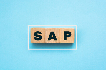 Wall Mural - Concept image of business acronym SAP as Systems Applications Products written over wooden blocks, blue background.