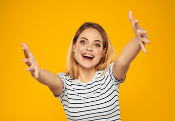 Wall Mural - cute blonde girl in striped t-shirt fun attractive look yellow background