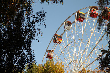 Ferris wheel. a park. summer. autumn. sky. blue. air. nature. town. entertainment. joy.