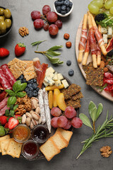 Wall Mural - Different tasty appetizers on dark grey table, flat lay