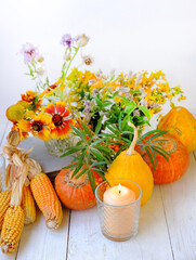 Sticker - pumpkins, corn, flowers and candle on white wooden background. autumn composition. symbol of harvest. fall season. Mabon, thanksgiving holiday, Halloween concept