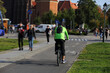 Młodzy mężczyzna jedzie na rowerze po ścieżce rowerowej we Wrocławiu.	