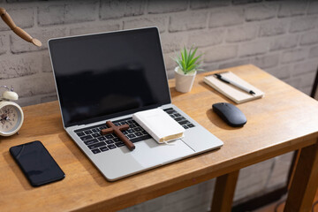 Wall Mural - Study Bible online concept. Wooden cross and laptop on wooden table.