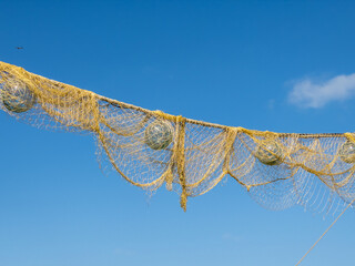 Fishing net with glass float with blue sky in background