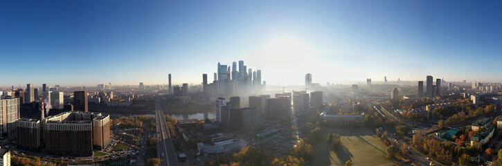 a panoramic view of the city business skyscrapers in the morning fog at sunrise filmed from a drone 