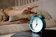© Artem - The girl turns off the alarm clock in the morning