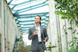© Acronym - A young successful businessman is walking down the street. Man in a casual wear. Business, freelance and remote work.