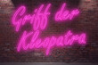 Neon Playing the flute (in german Griff der Kleopatra) lettering on Brick Wall at night