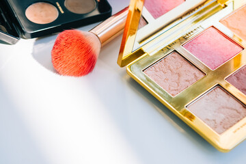 cosmetic brush and eyeshadow palette for make up on white table, beauty accessories.