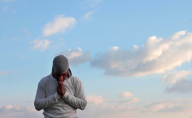 Wall Mural - man praying to god with arms outstretched looking up to the sky stock photo	