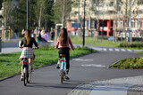 Dwie piękne kobiety jadą rowerami ścieżką rowerową w mieście, Wrocław.