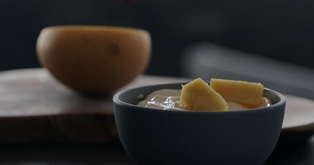 Wall Mural - Slow motion put fresh thai mango in natural organic yogurt in blue bowl