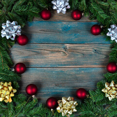 Canvas Print - Top view of a complete wreath, bows and red ball ornaments in circle border on blue aged wooden planks for the winter holiday season of Christmas or New Year background