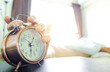 © Media  - Man sleeping in a bedroom holiday. Hand holding a alarm clock in the morning. concept of health.
