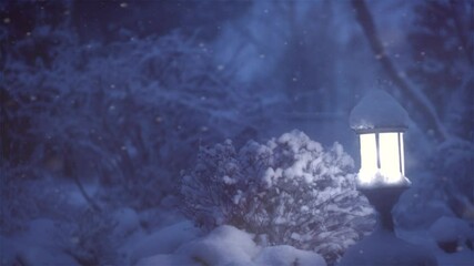 Wall Mural - Winter scene with snow. Xmas Decoration with a lantern on snow in a winter garden. Christmas Background. Lamp at night. Garden design. Snowing. Slow motion video 240 fps. 