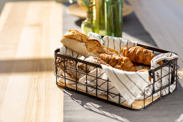Aufkleber - Basket with various homemade baked goods, baguette, ciabatta and croissant on wooden kitchen table, copy space
