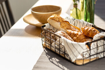 Aufkleber - Basket with various homemade baked goods, baguette, ciabatta and croissant on wooden kitchen table, copy space