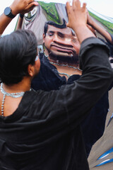 Wall Mural - portrait of dark skinned Indian man looking into a distorted mirror