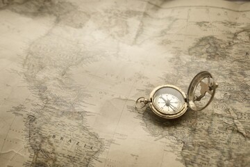 Retro style antique golden compass (sundial) and old nautical chart close-up. Vintage still life. Sailing accessories. Wanderlust, travel and navigation theme. Graphic resources, copy space