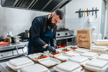 Food in disposable dishes ready for delivery. The chef prepares food in the restaurant and packs it in disposable lunch boxes.