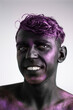 © arrideo - Headshot of cheerful smiling young man with black and purple makeup