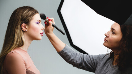 Canvas Print - Backstage of the photo shoot: Make-up artist applies makeup on beautiful white  model. Tutorial makeup master class.