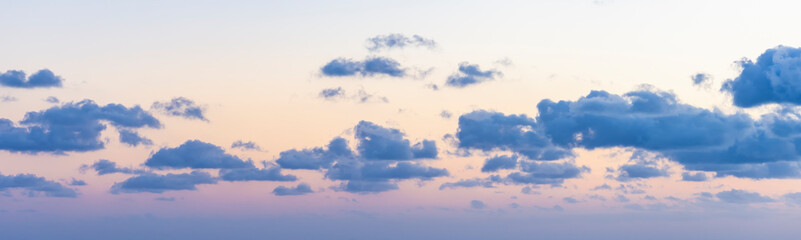 Wall Mural - Natural background, stunning view of some fluffy clouds on a purple and orange sky during a beautiful sunrise. Sardinia, Italy.