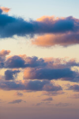 Wall Mural - Natural background, stunning view of some fluffy clouds on a purple and orange sky during a beautiful sunrise. Sardinia, Italy.
