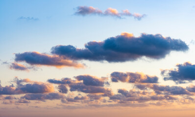 Wall Mural - Natural background, stunning view of some fluffy clouds on a purple and orange sky during a beautiful sunrise. Sardinia, Italy.