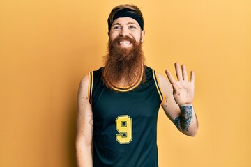 Poster - Redhead man with long beard wearing basketball uniform showing and pointing up with fingers number four while smiling confident and happy.